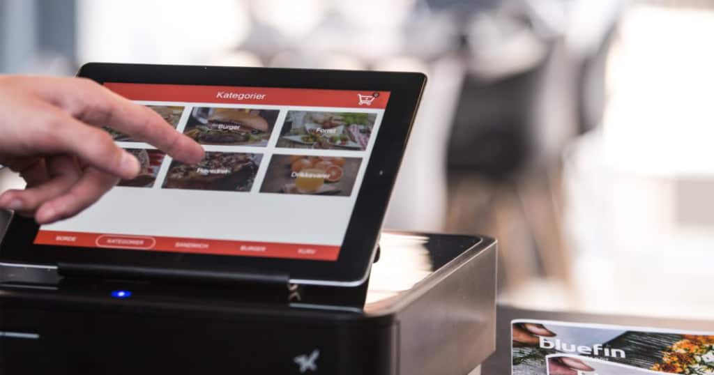 Restaurant personnel using digital device to manage orders