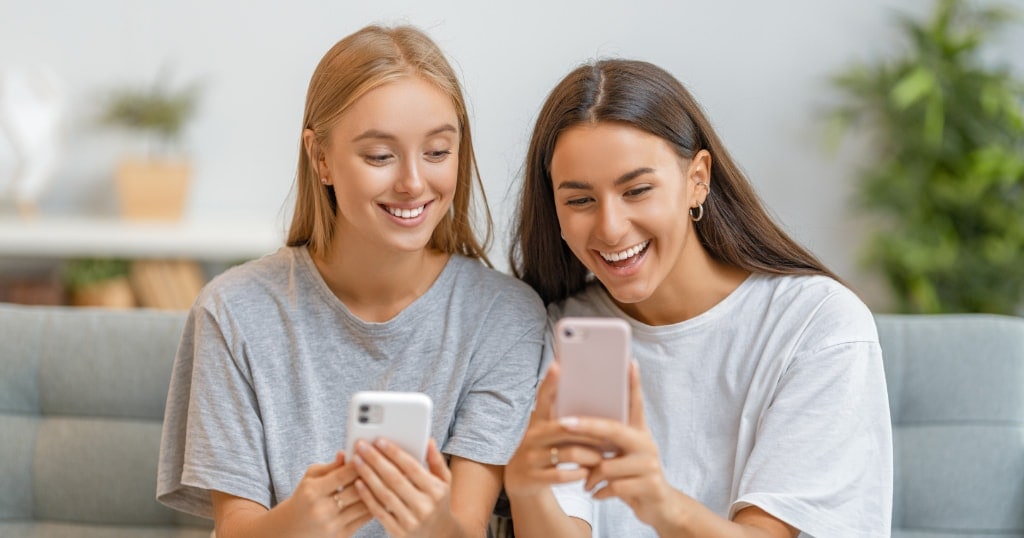 Young women looking at their social media and smiling