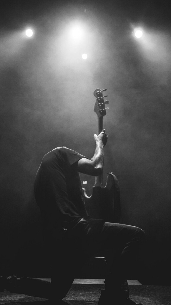 Guitarist kneeling down while playing at a concert